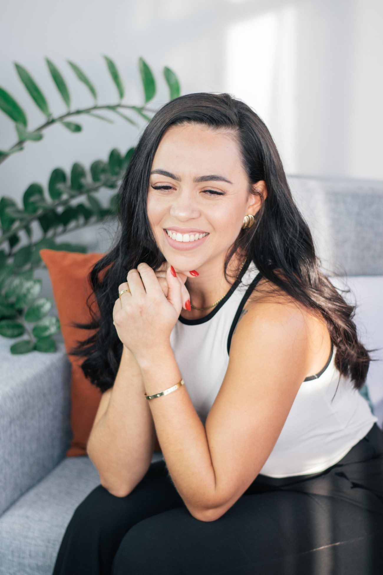 Psicóloga Rosana Ruiz sorrindo, sentada em um sofá